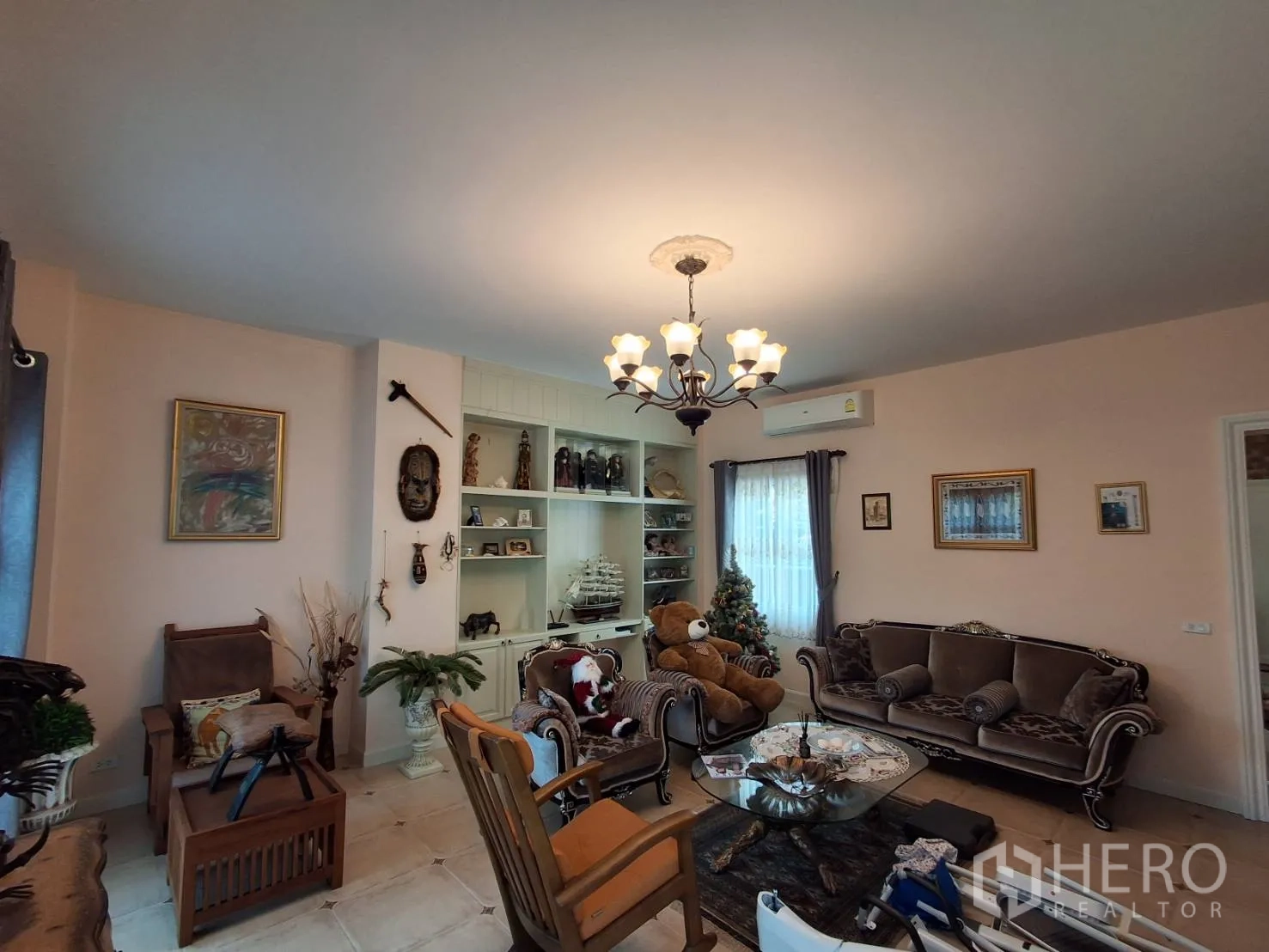 Detached House for rent or sale in Ban Chang, Rayong - Classic living area with sofa set, built-in display shelves and chandelier.