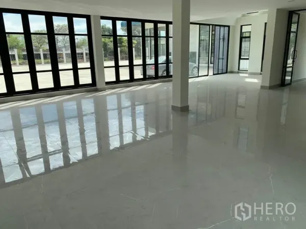 Warehouse for rent in Bang Phli, Samut Prakan - Open-plan showroom or office space with floor-to-ceiling windows and sliding glass doors facing the yard.
