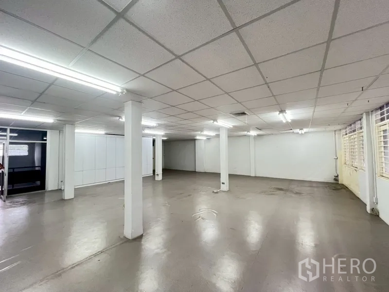 店屋 出租在Phra Khanong, Bangkok - 楼上宽敞房间另一角度，立柱与整排窗户。