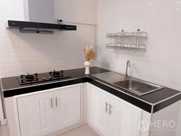 ทาวน์เฮาส์ ให้เช่าในHuai Khwang, Bangkok - ครัวรูปตัวแอลทันสมัย มีเตาแก๊ส เครื่องดูดควัน อ่างล้างจาน และตู้เก็บของสีขาว