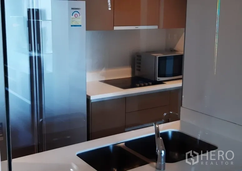 คอนโด ให้เช่าในKhlong Toei, Bangkok - ครัวคอนโดสไตล์โมเดิร์น มีอ่างล้างจานคู่ ตู้เย็นสแตนเลส ไมโครเวฟ และเตาไฟฟ้าพร้อมตู้บิวต์อินเงาวาว