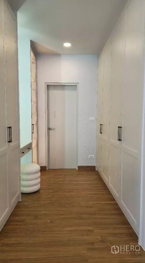 Detached House for rent or sale in Bang Phli, Samut Prakan - Walk-in closet corridor featuring floor-to-ceiling wardrobes and a dressing vanity.