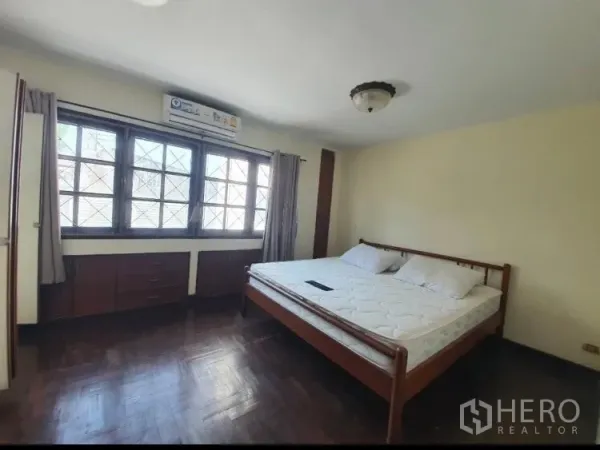 Townhouse for rent in Watthana, Bangkok - Spacious master bedroom with parquet floor and built-in storage.