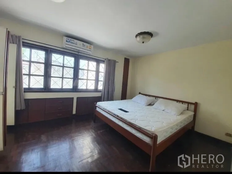 Townhouse for rent in Watthana, Bangkok - Spacious master bedroom with parquet floor and built-in storage.
