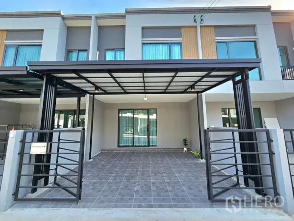 Townhouse for rent in Bang Phli, Samut Prakan - Front view of the townhouse showing tiled driveway and carport roof.