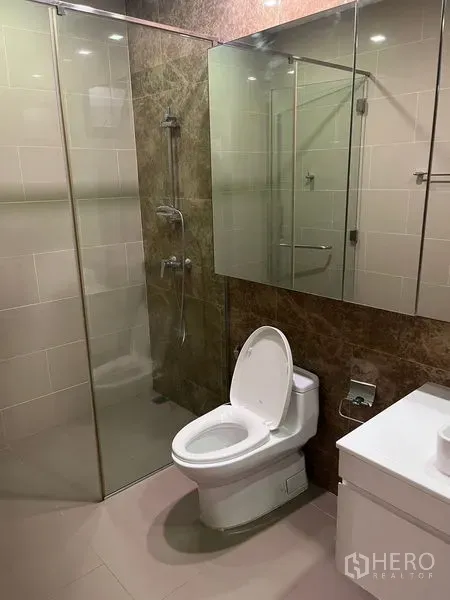 独立式住宅 出租在Wang Thonglang, Bangkok - 现代浴室，玻璃淋浴间、坐便器与镜面收纳柜一体。