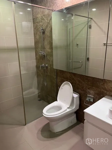 独立式住宅 出租在Wang Thonglang, Bangkok - 现代浴室，玻璃淋浴间、坐便器与镜面收纳柜一体。