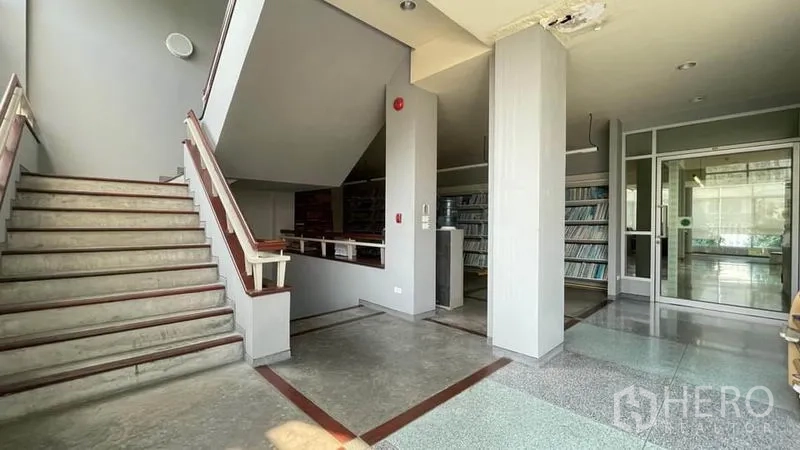 คลังสินค้า ขายในBangkok Yai, Bangkok - โถงบันไดพร้อมชั้นวางบิลท์อินและประตูกระจกเข้าอาคาร