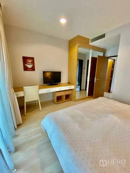 คอนโด ให้เช่าหรือขายในWatthana, Bangkok - มุมห้องนอนมีโต๊ะบิลท์อิน ทีวี และตู้เสื้อผ้าบานกระจกใกล้ประตู