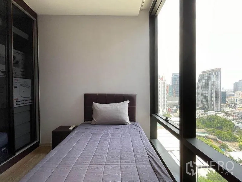 Condominium for rent in Bang Rak, Bangkok - Compact bedroom with single bed and wall-to-wall windows overlooking Bangkok.