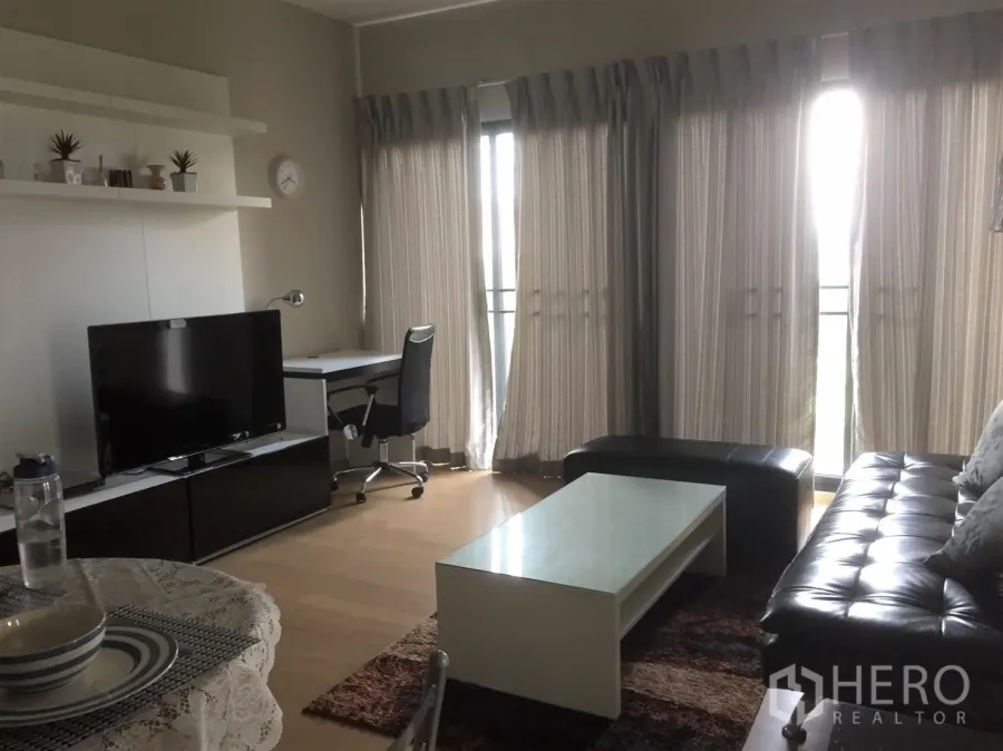 คอนโด ให้เช่าในWatthana, Bangkok - ห้องนั่งเล่นโปร่งสว่าง มีหน้าต่างสูง มุมทำงาน ทีวี และโซฟาหนัง