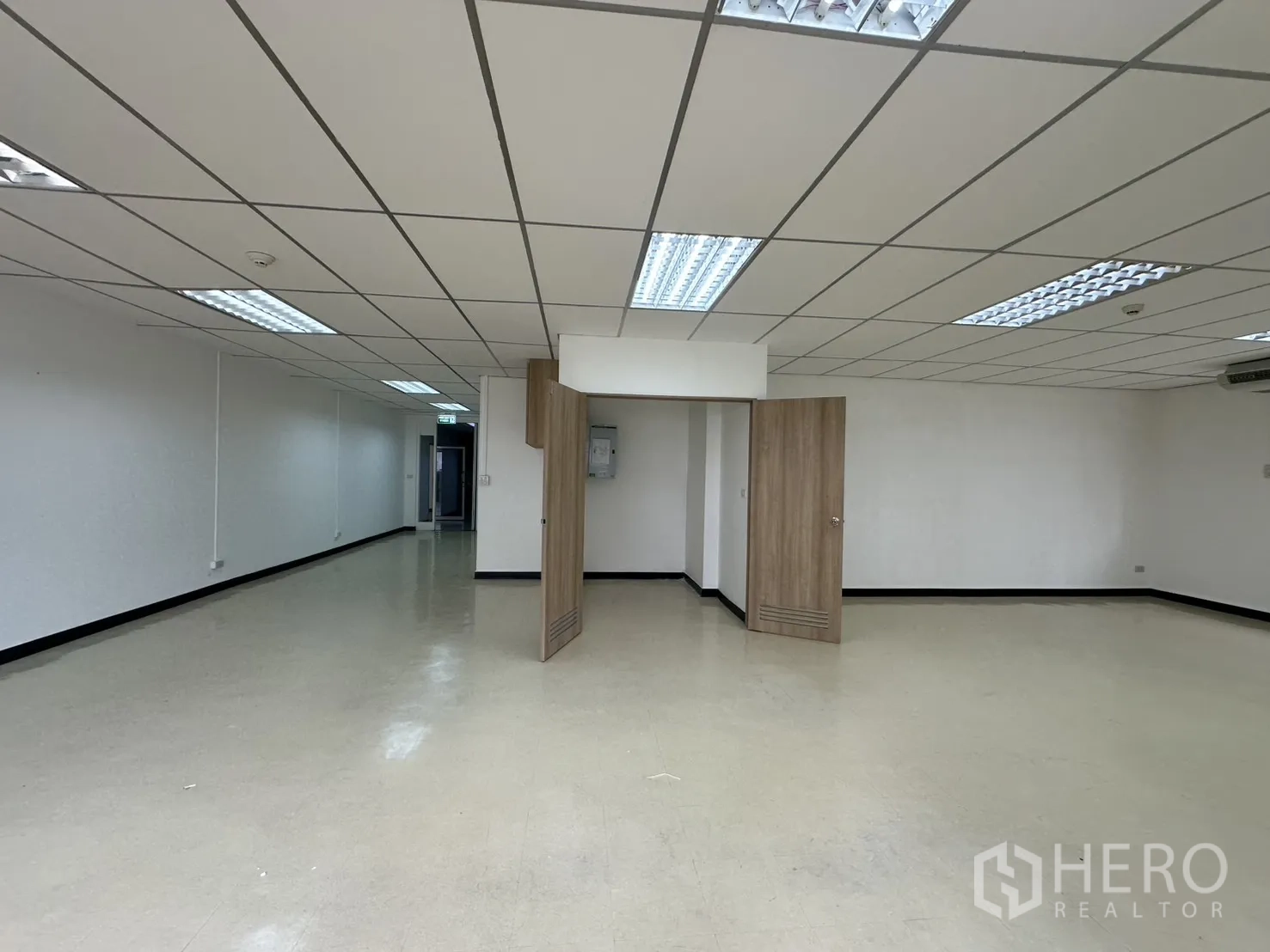 ออฟฟิศ for rent in Pathum Wan, Bangkok - พื้นที่สำนักงานกว้างพร้อมฉากกั้นบานพับไม้ พื้นไวนิลสีอ่อน และไฟฝ้าเพดาน.
