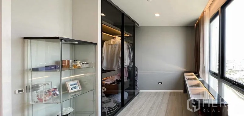 Condominium for rent or sale - Walk-in wardrobe with glass sliding doors, display cabinet and large windows bringing in natural light.