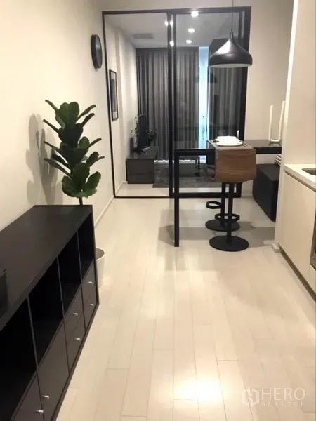 Condominium for rent or sale in Pathum Wan, Bangkok - Open-plan corridor with kitchenette and bar dining, glass partition to the living area.
