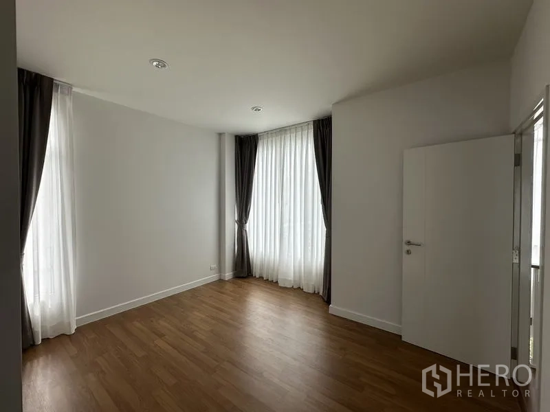 บ้าน ขายในLam Luk Ka, Pathum Thani - ห้องนอนรับแสงดี พื้นลามิเนต และหน้าต่างม่านโปร่งสูง