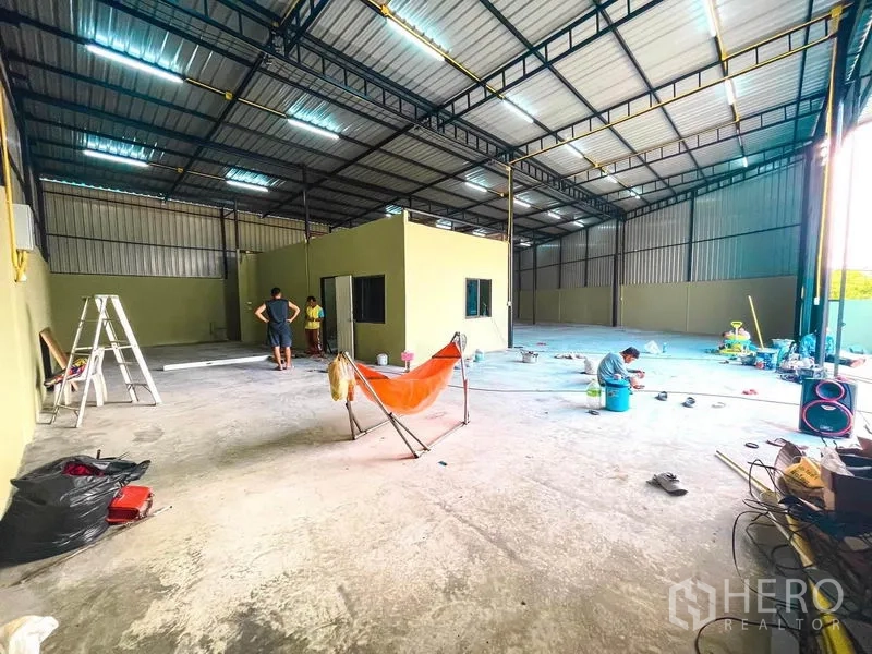 Warehouse for rent in Sai Mai, Bangkok - Open-plan warehouse interior with central office cabin and wide loading entrance.