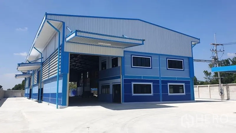 工厂 出租或出售在Phanat Nikhom, Chon Buri - 厂房正立面，办公室窗户与带雨棚的装卸口。