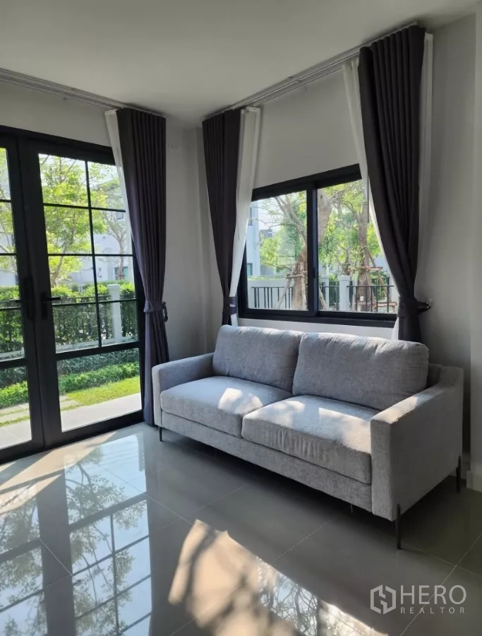 Detached House for rent in Bang Phli, Samut Prakan - Corner living area with grey sofa and floor-to-ceiling windows