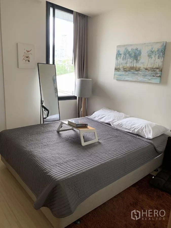 公寓 出租在Watthana, Bangkok - 次卧配灰色床品、立式镜与挂画，采光良好