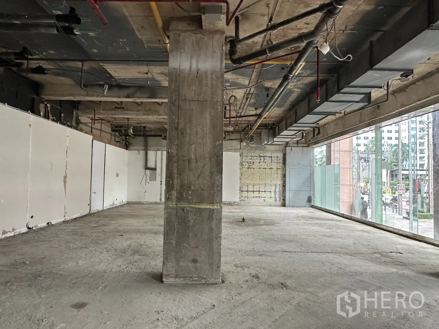 พื้นที่ขายของ for rent in Watthana, Bangkok - พื้นที่ภายในแบบเปลือกอาคาร เพดานเปลือย เสากลาง และกระจกบานสูงติดถนน