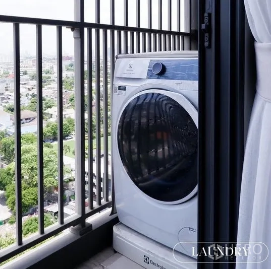 公寓 出租在Watthana, Bangkok - 阳台放置滚筒洗衣机，栏杆外是城市景观