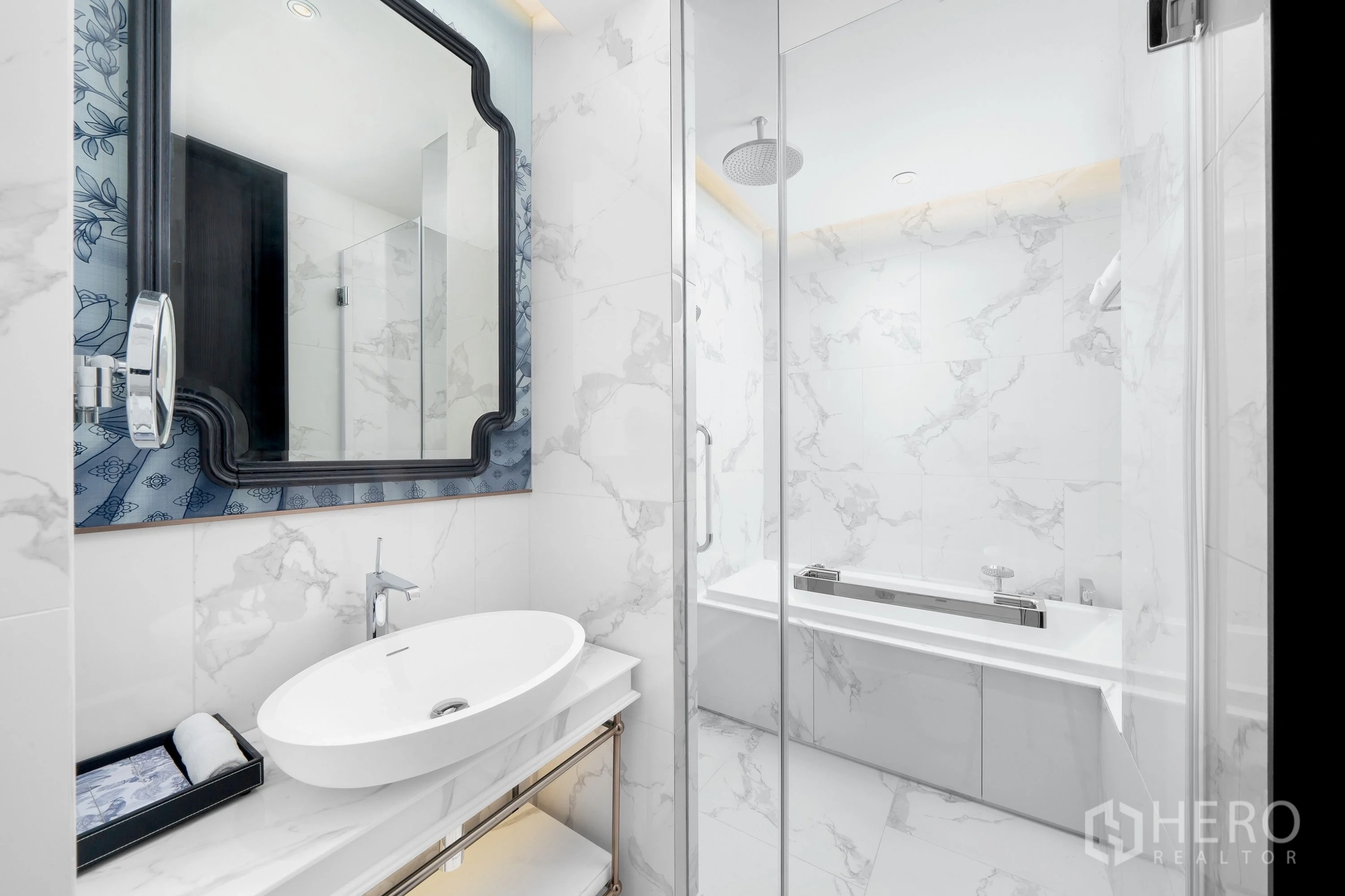 Condominium for rent in Khlong Toei, Bangkok - Close-up of vanity with framed mirror and glass shower beside a soaking tub.