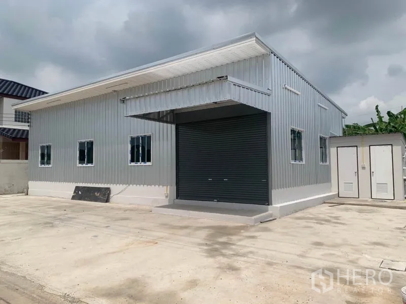 คลังสินค้า ให้เช่าหรือขายในThanyaburi, Pathum Thani - ด้านหน้าโกดัง ประตูม้วนขนาดใหญ่ พร้อมทางเข้าจอดรถกว้าง