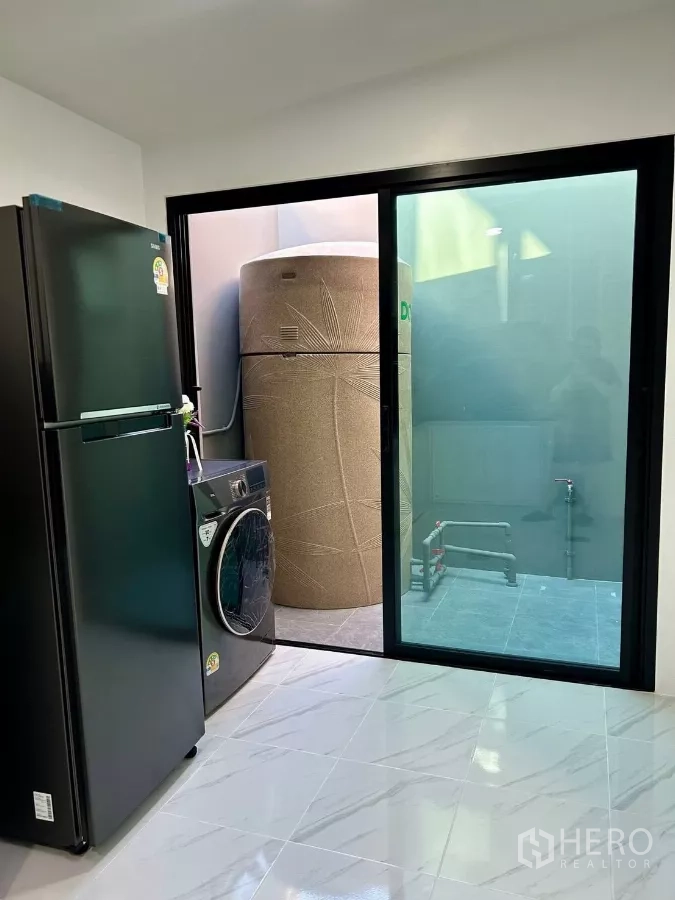 Townhouse for rent in Bang Phli, Samut Prakan - Utility area with refrigerator, washer-dryer and sliding door to service yard.