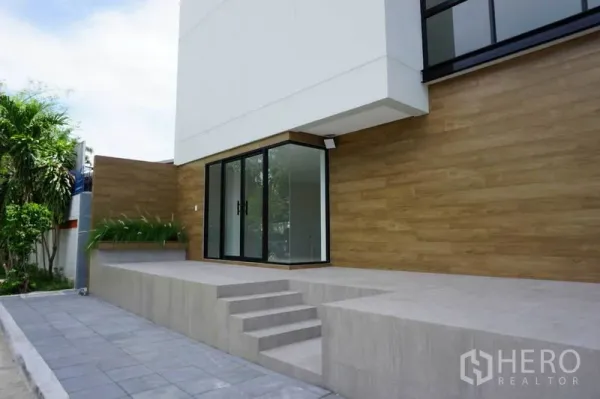 สำนักงาน ให้เช่าในPrawet, Bangkok - ชานทางเข้ายกสูงพร้อมขั้นบันได ผนังลายไม้ และประตูกระจกเข้าสู่ล็อบบี้