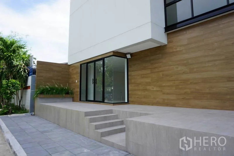 สำนักงาน ให้เช่าในPrawet, Bangkok - ชานทางเข้ายกสูงพร้อมขั้นบันได ผนังลายไม้ และประตูกระจกเข้าสู่ล็อบบี้