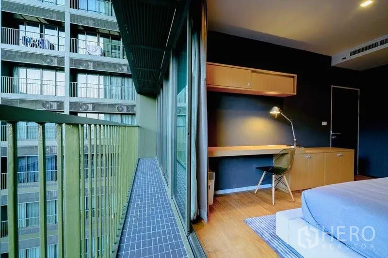 Condominium for rent in Watthana, Bangkok - Narrow balcony outside bedroom with sliding glass doors and study desk inside.