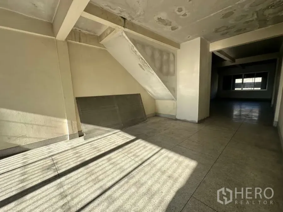 สำนักงาน ให้เช่าในPhra Khanong, Bangkok - ภายในสำนักงานเปล่า พื้นกระเบื้อง แสงธรรมชาติ และมุมเก็บของใต้บันไดพร้อมพื้นที่เปิดโล่งลึก