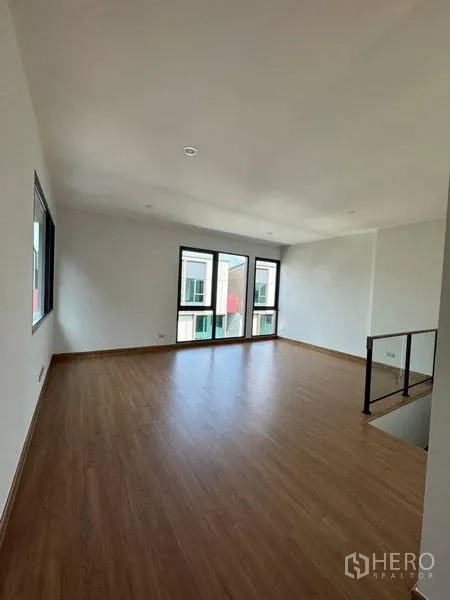 Townhouse for rent - Spacious upper-floor living area with timber floor and balcony doors.