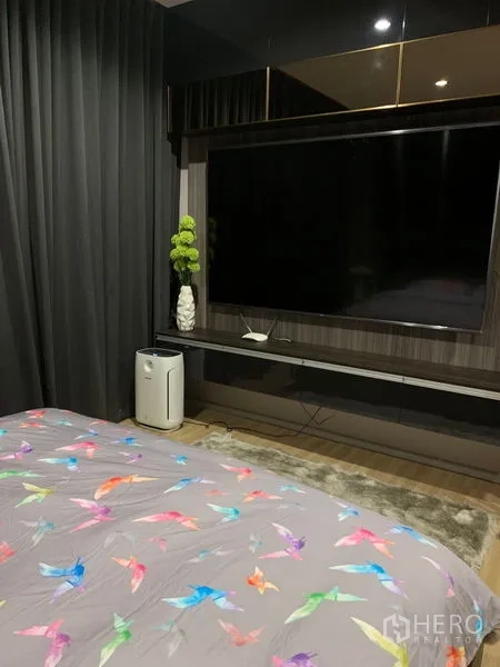 สำนักงานที่บ้าน ให้เช่าในSaphan Sung, Bangkok - ผนังทีวีในห้องนอนหลัก หน้าจอขนาดใหญ่ ม่านสีเข้มและงานไม้