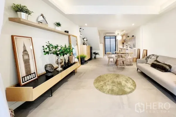 联排别墅 出租在Khlong Toei, Bangkok - 开放式客餐厅与厨房相连，壁挂隔板与装饰摆件。