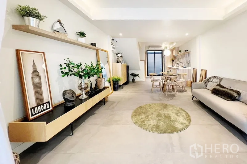 联排别墅 出租在Khlong Toei, Bangkok - 开放式客餐厅与厨房相连，壁挂隔板与装饰摆件。