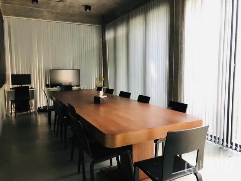 อาคารพาณิชย์ ให้เช่าในChatuchak, Bangkok - ห้องประชุมโต๊ะไม้ยาว เก้าอี้สีดำ เพดานปูน และม่านบังแสงแนวตั้ง