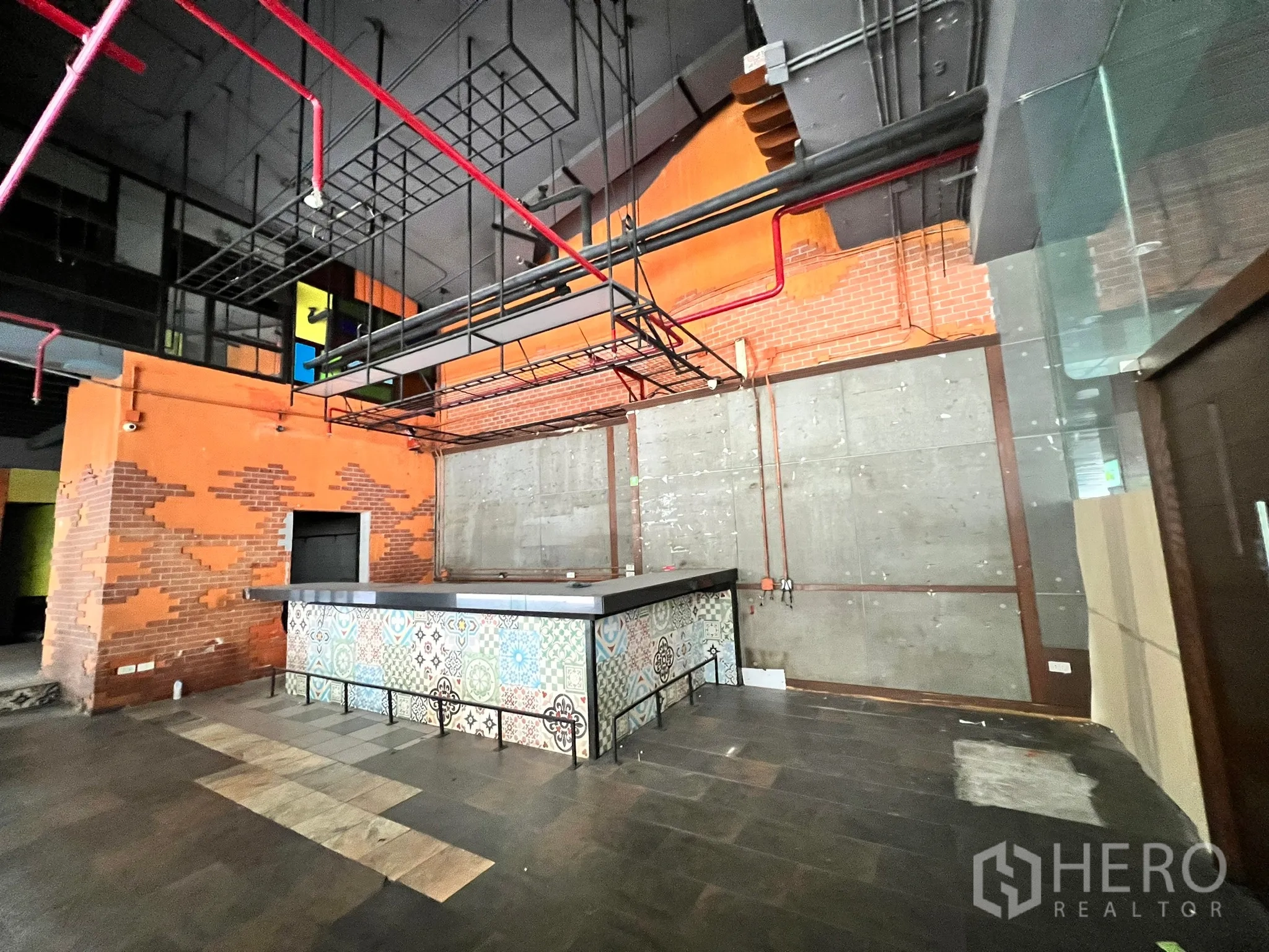 零售空间 出租在Watthana, Bangkok - 宽角度展示花纹吧台、高挑黑色天花与红色喷淋管。