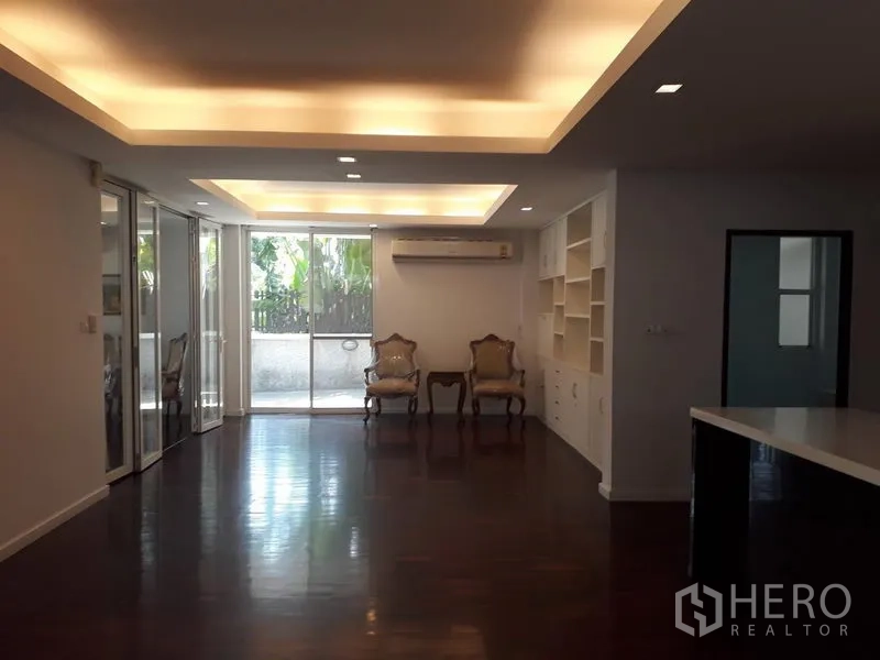 บ้าน ให้เช่าในWatthana, Bangkok - โถงรับแขกแบบโอเพนเพลน เพดานซ่อนไฟ ประตูกระจกสไลด์ และชั้นวางบิวท์อิน