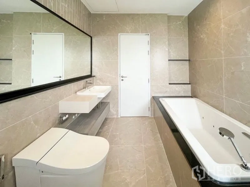 独立式住宅 出租 - 主浴室配双洗手台、长镜与内置浴缸。