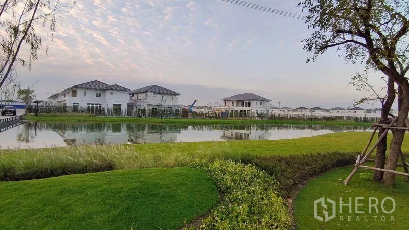 บ้าน ให้เช่าในPrawet, Bangkok - ทะเลสาบภายในโครงการพร้อมภูมิทัศน์สีเขียวและบ้านโดยรอบ.