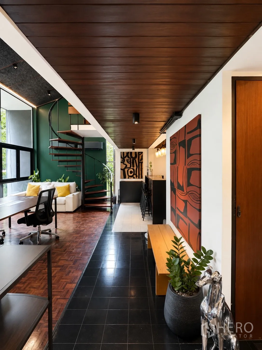 办公室 for rent in Phaya Thai, Bangkok - 入口走廊设长凳、绿植与艺术装饰，可见吧台和螺旋楼梯。