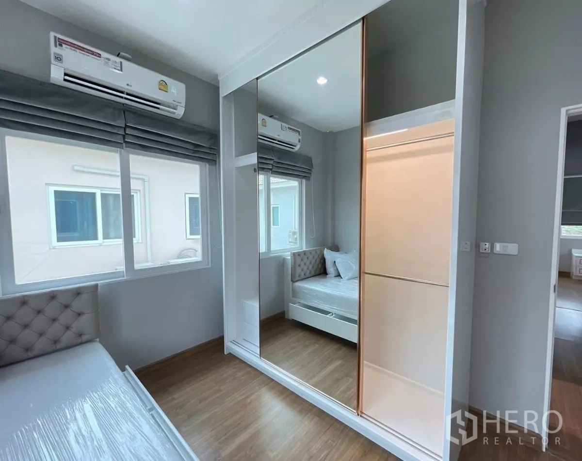 独立式住宅 出租在Bang Khen, Bangkok - 卧室内设镜面推拉衣柜与空调。