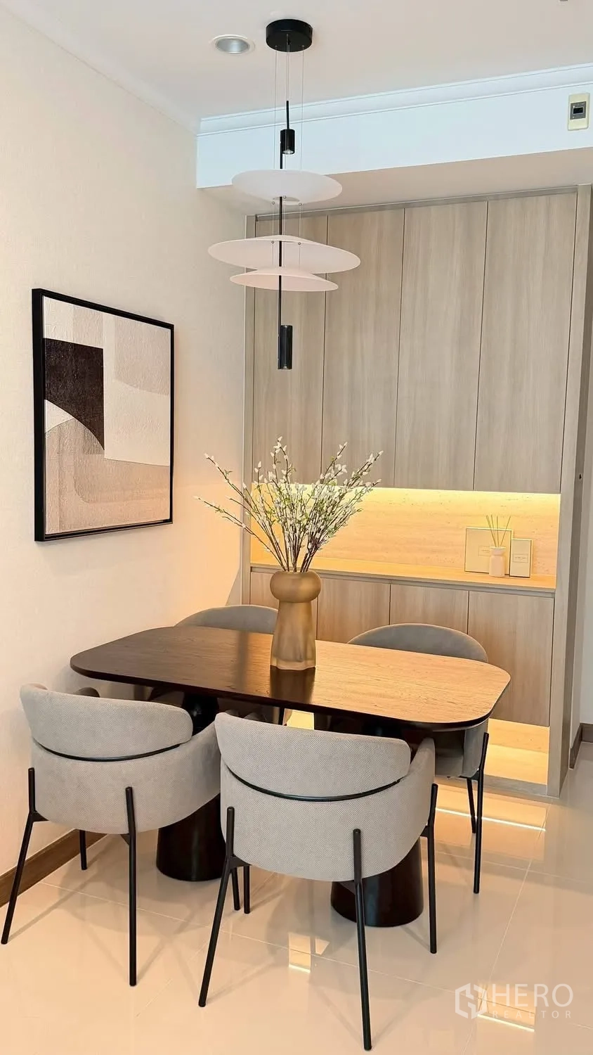 Condominium for rent in Watthana, Bangkok - Dining area with a wooden table, four upholstered chairs, and a pendant light.