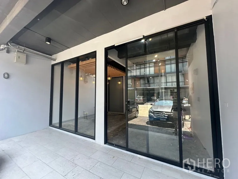 Home Office for rent - Covered front terrace with floor-to-ceiling glass storefront and parking view.