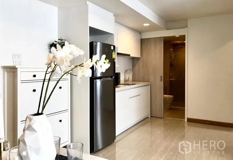 คอนโด ให้เช่าในWatthana, Bangkok - ครัวแพนทรีโทนขาว ตู้บิวท์อิน ตู้เย็นสแตนเลส และประตูบานเลื่อนเชื่อมห้องน้ำในคอนโดสว่างโปร่ง