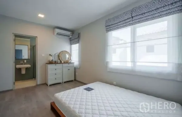 Detached House for rent in Prawet, Bangkok - Second bedroom with en-suite bathroom, air conditioner and twin windows with Roman shades.