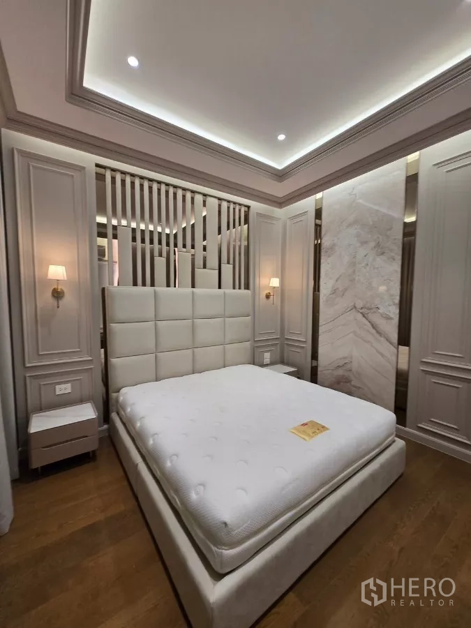 Detached House for rent or sale in Bang Kapi, Bangkok - Bedroom with panelled walls, cove lighting and platform bed with mattress.