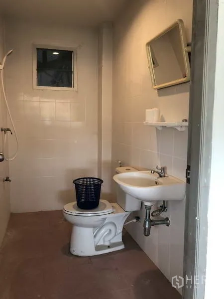 联排别墅 出售在Bang Bua Thong, Nonthaburi - 简洁卫生间，配淋浴、坐便、洗手盆与小窗。