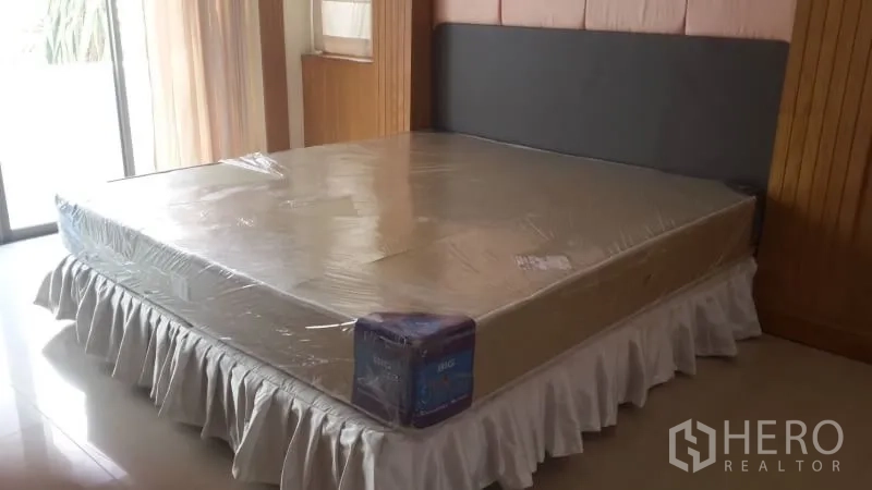 บ้าน ให้เช่าหรือขายในHuai Khwang, Bangkok - ห้องนอนสว่าง มีที่นอนใหม่หุ้มพลาสติก ประตูกระจกบานเลื่อน และงานไม้โทนอ่อน